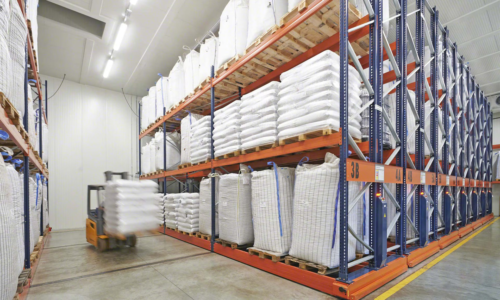 Warehouse with in-shell hazelnuts stored on raised pallets, with space for ventilation between rows.